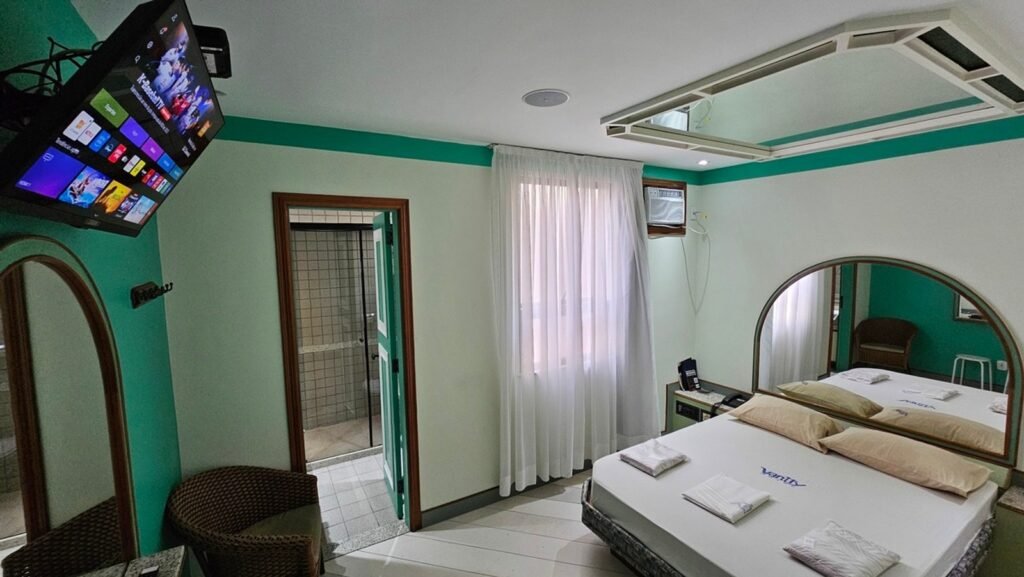 Suíte Copacabana com paredes turquesa e cama de casal